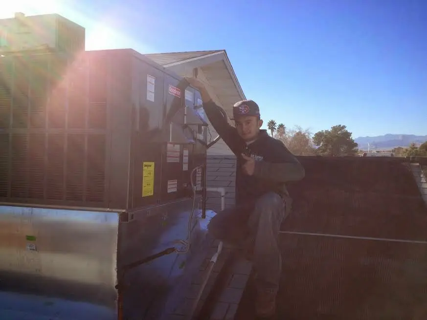 HVAC technician performing Air Duct Repair on a rooftop unit in Greenwood